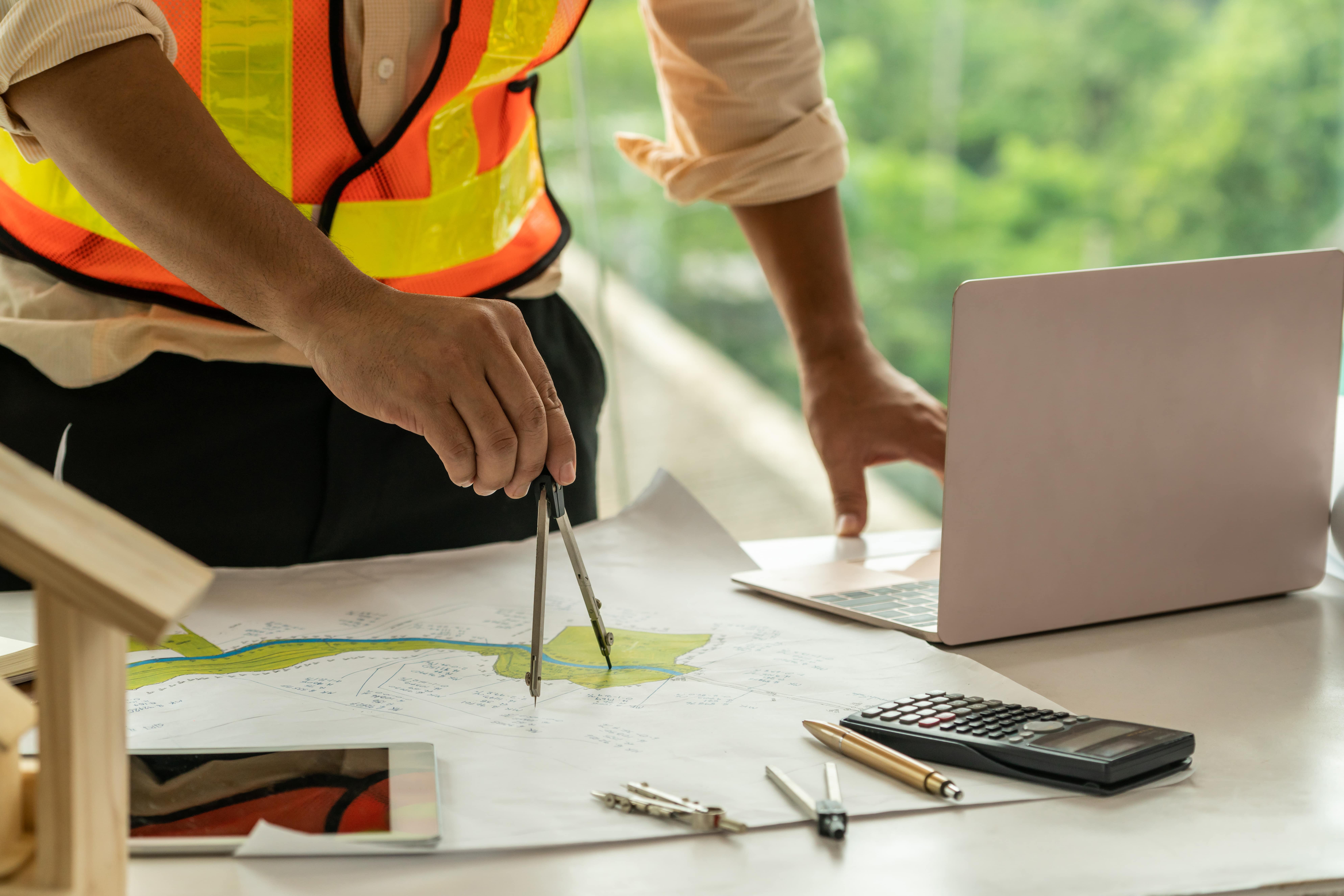 Picture of an Engineer using a compass on a plan